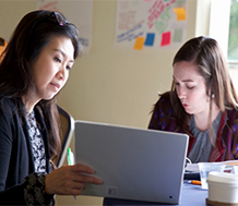 Adult with student at computer