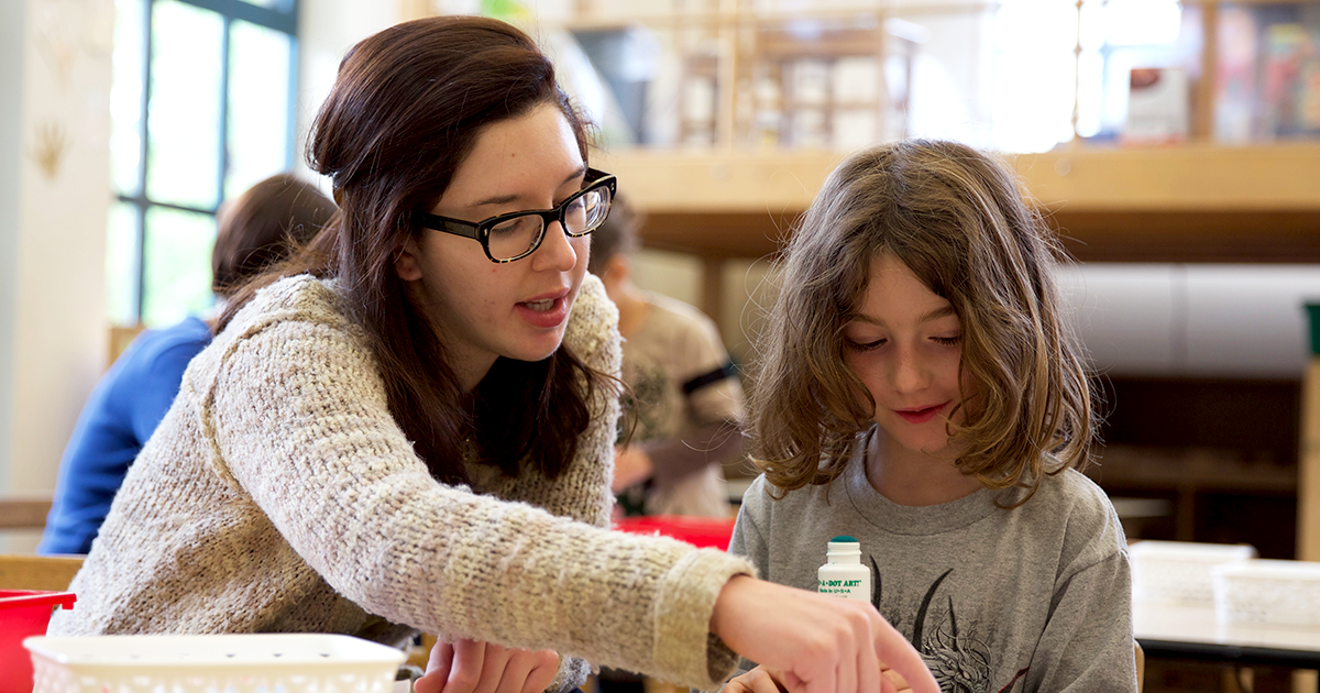 Young student with teacher in a classroom