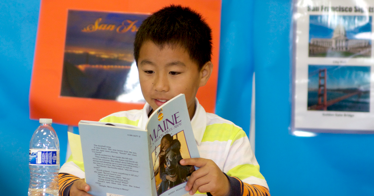 young boy reading a book