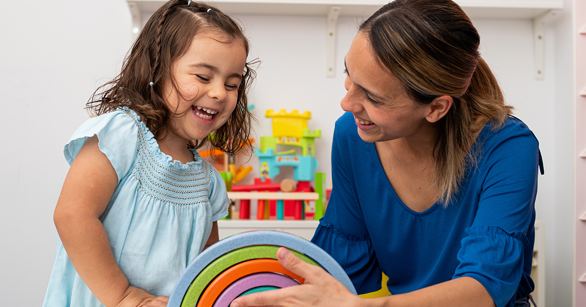 An early childhood caregiver teaching her student.