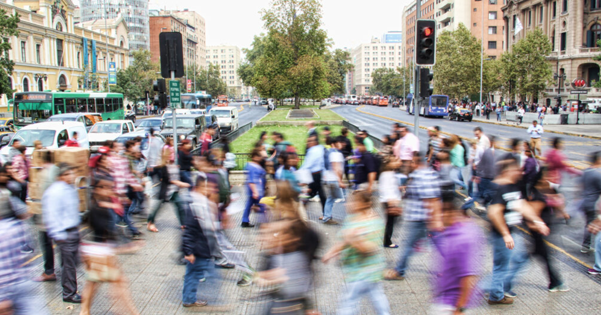 A crowd of people walking through a city.